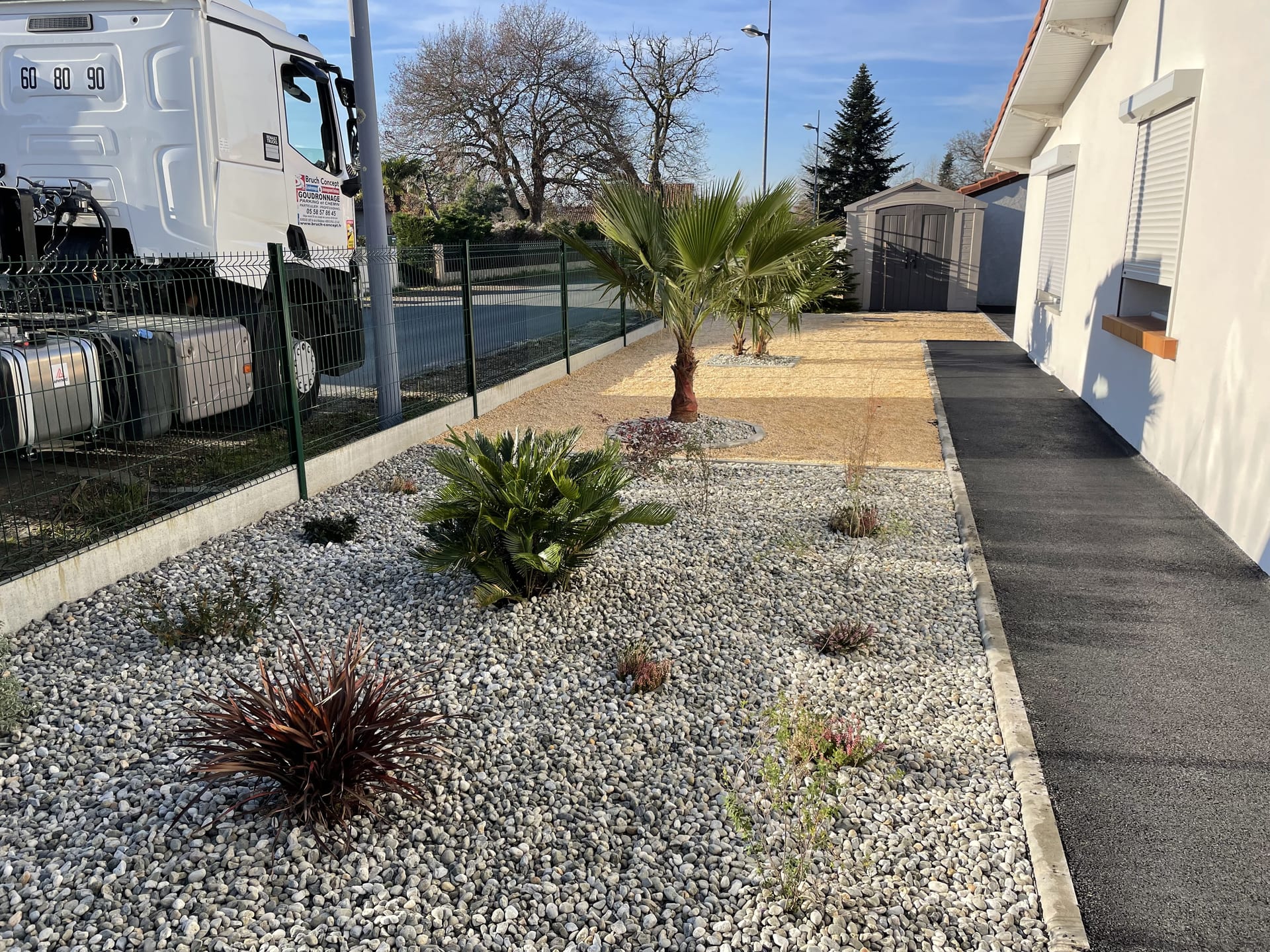 Cour enrobé noir bordée de jardin minéral en galets blancs — Anglet (64)