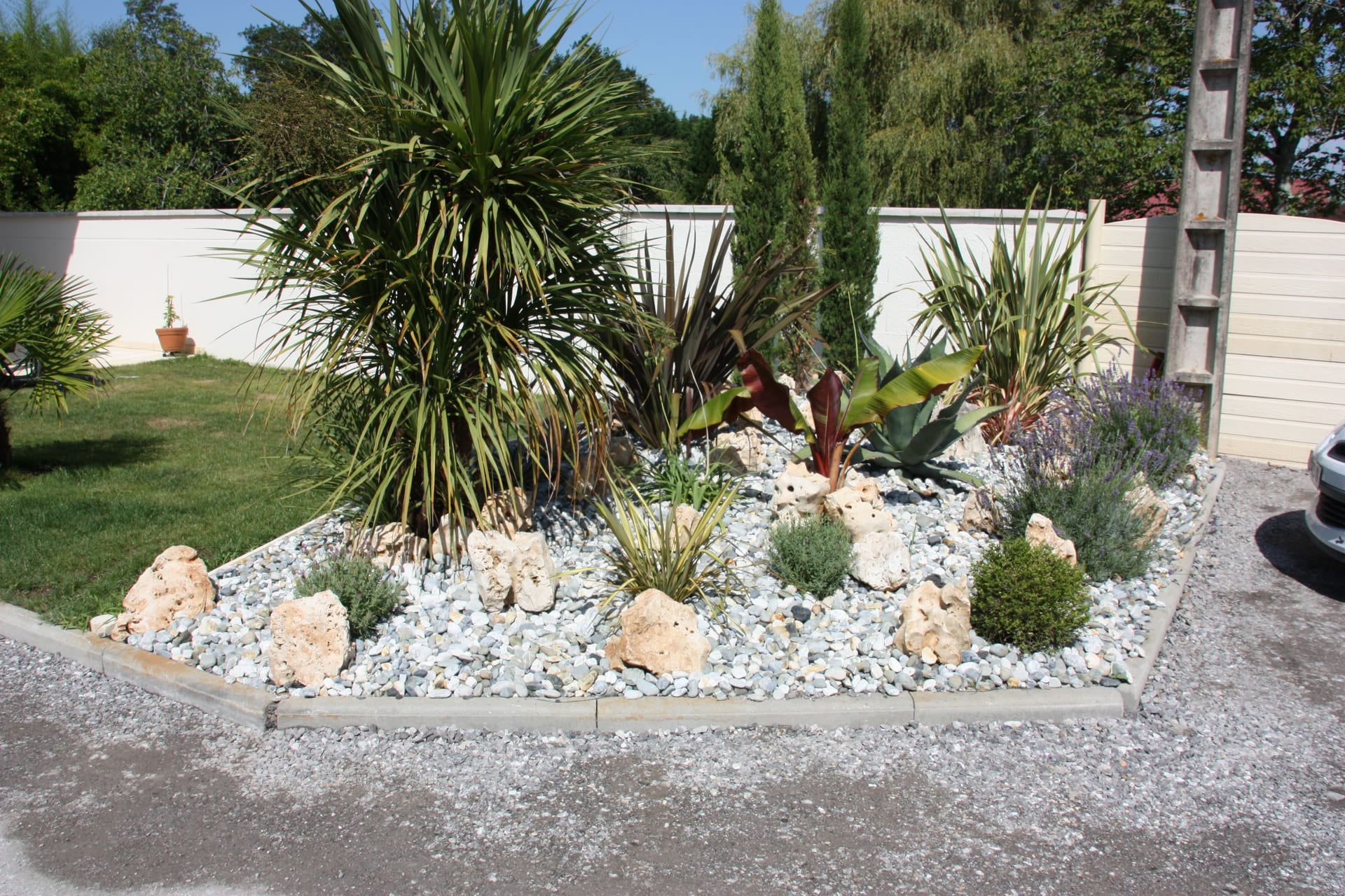 Massif rocaille avec graminées et palmiers — entrée de villa à Soustons (40)